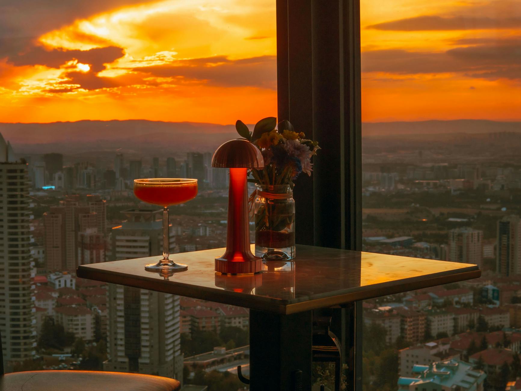 Liverpool Nightlife Guide: Bars, Clubs & Live Music 4 A rooftop bar overlooking Liverpool's city skyline at sunset, offering panoramic views with cocktails