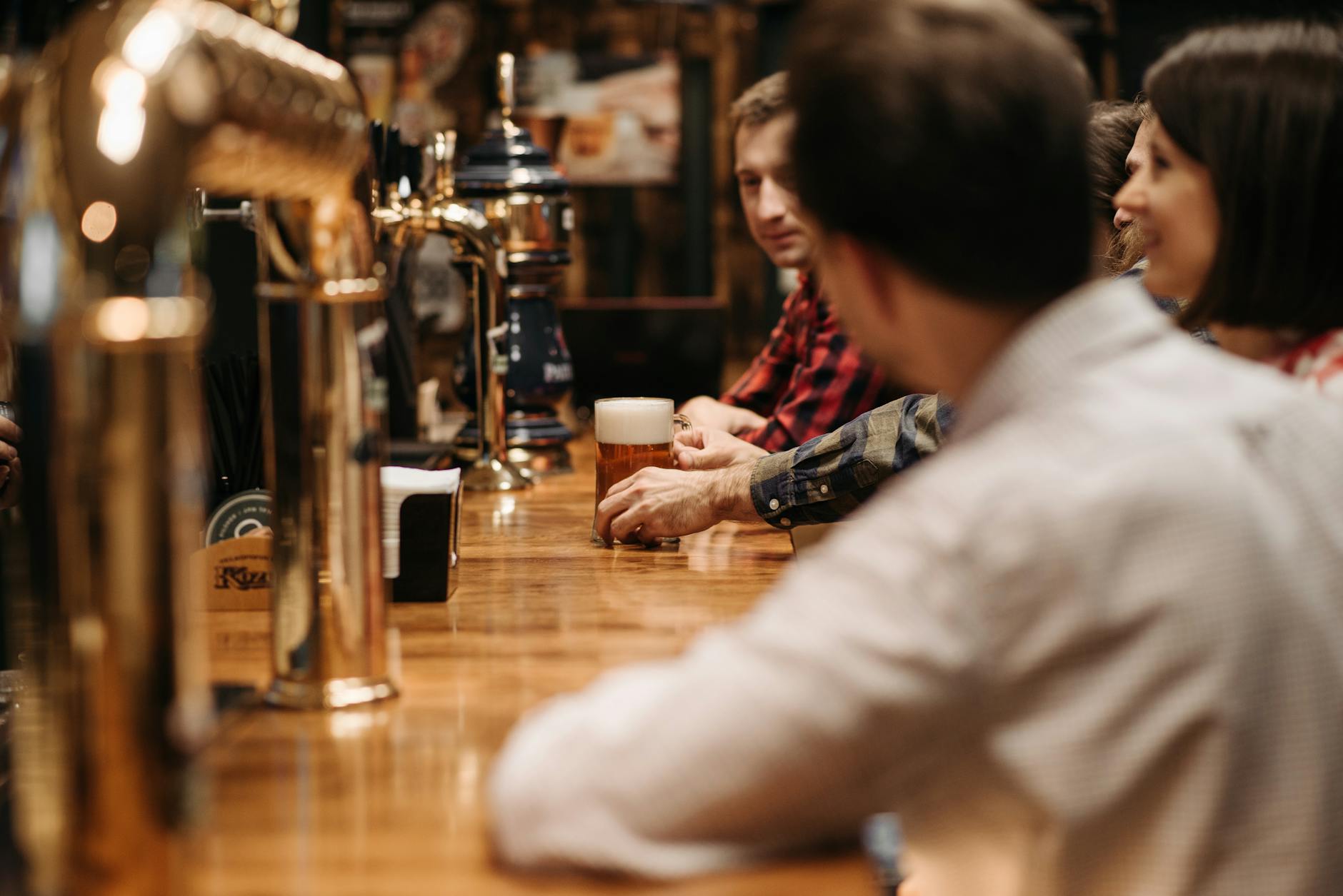 A group of friends drinking together at a traditional bar in a Liverpool pub