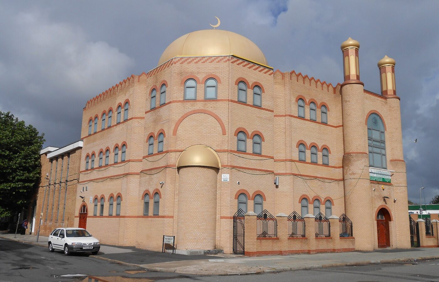 Liverpool for Muslim Travellers: Halal Food, Mosques & Prayer Spaces 4 Al-Rahma Mosque on Hatherley Street, Toxteth, Liverpool: a sandy-brick building with arched windows, a large gold dome topped with a crescent and two gold-capped minarets