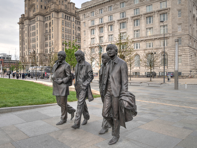 Best Things to Do in Liverpool on a Cruise Stop 4 The bronze Beatles statue at the Pier Head in Liverpool, with the Royal Liver Building and Cunard Building behind