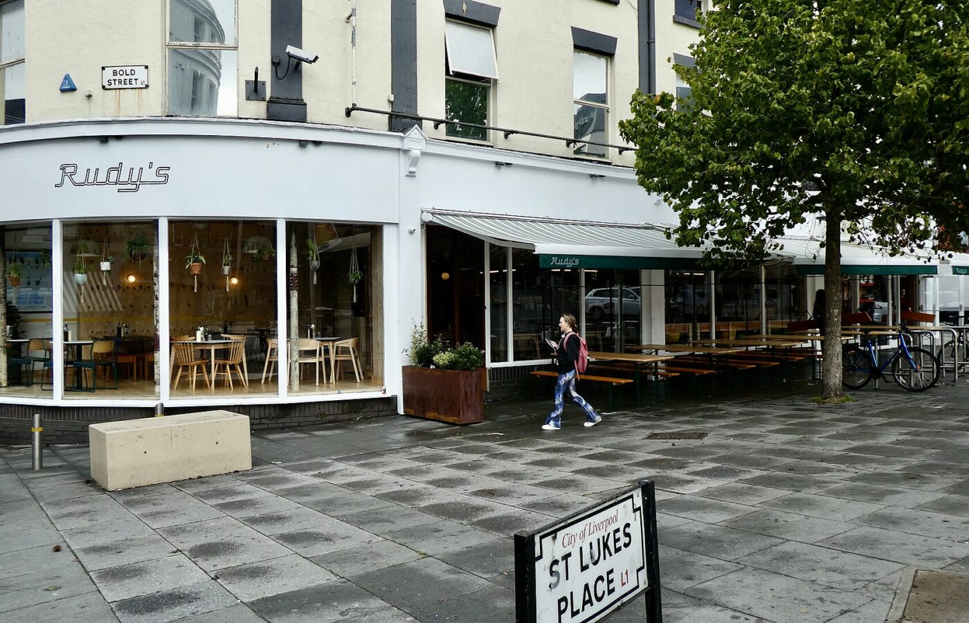 Ropewalks Liverpool: Bold Street, Seel Street & Duke Street Guide 5 A corner restaurant with outdoor benches at the top of Bold Street, Liverpool, beside the St Lukes Place street sign