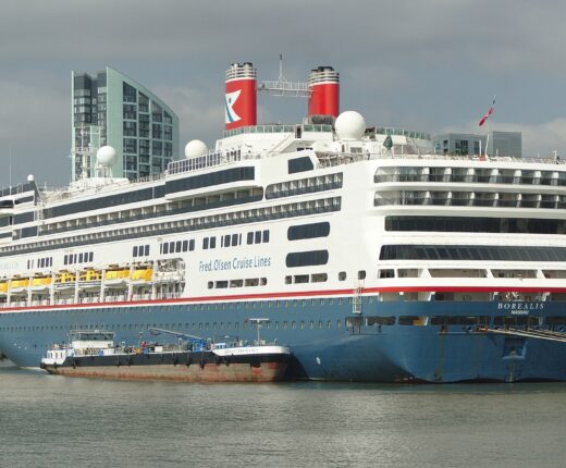 The Fred. Olsen cruise ship Borealis moored at Liverpool Cruise Terminal with a bunkering barge alongside and Princes Dock tower blocks behind