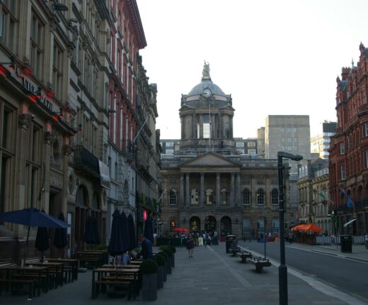 Castle Street in Liverpool lined with ornate Victorian bank buildings and café tables, leading to the domed Town Hall