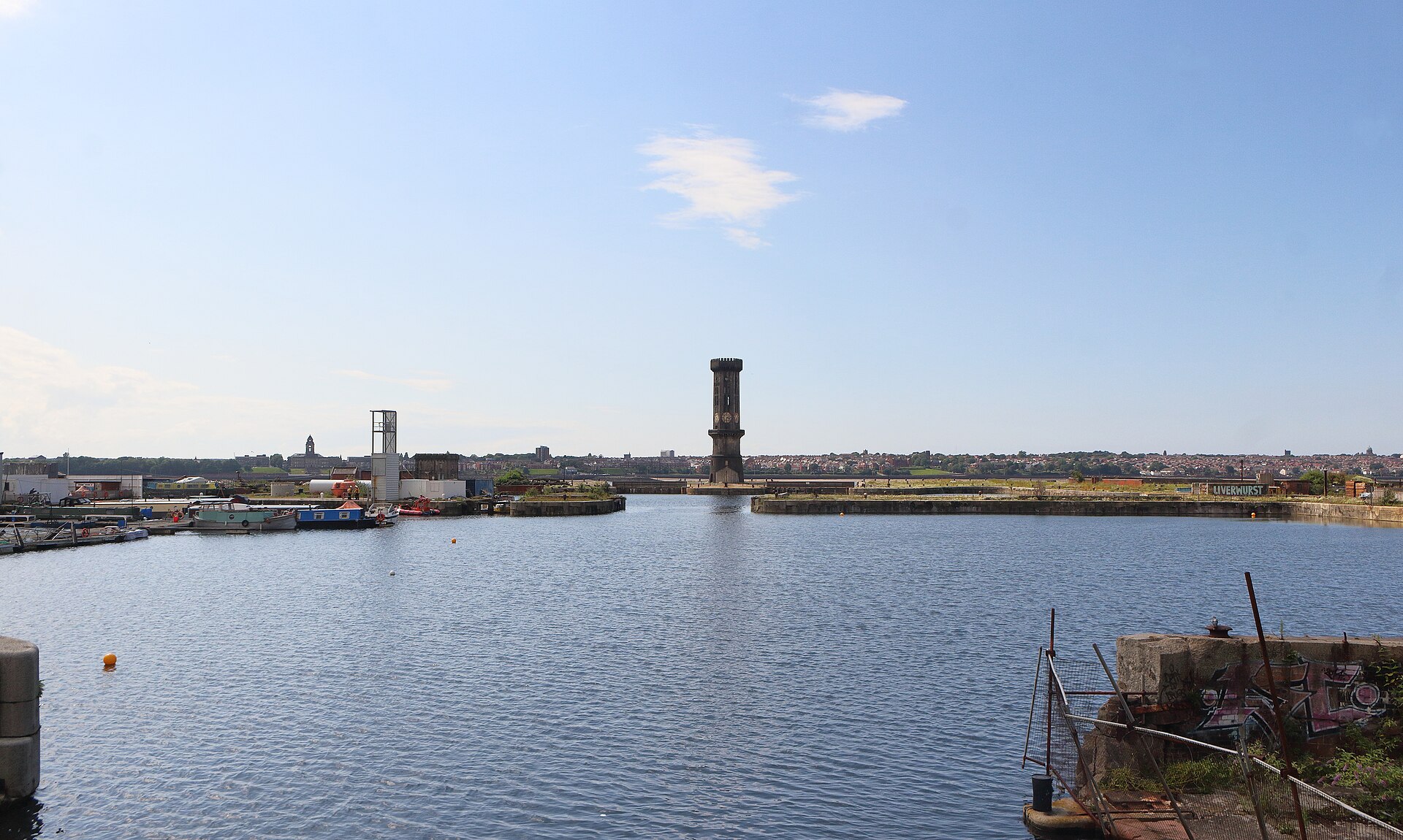 Stanley Dock & the Tobacco Warehouse: Liverpool's Film Backlot 4 Collingwood Dock in Liverpool on a sunny day, with narrowboats moored on the left and Jesse Hartley's granite Victoria Tower standing at the far end of the water