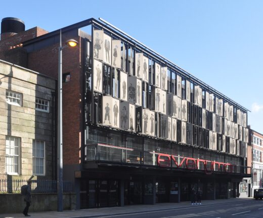 The Everyman Theatre on Hope Street, Liverpool, its upper floors screened by metal panels bearing life-size portraits of local people, above a red Everyman sign