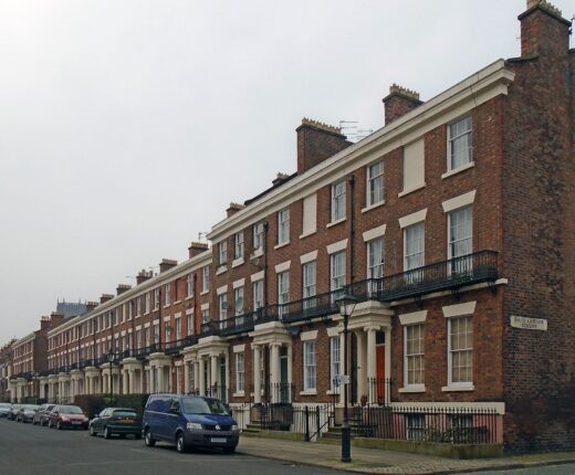 A long Georgian brick terrace with iron balconies running up Huskisson Street in Liverpool towards the cathedral