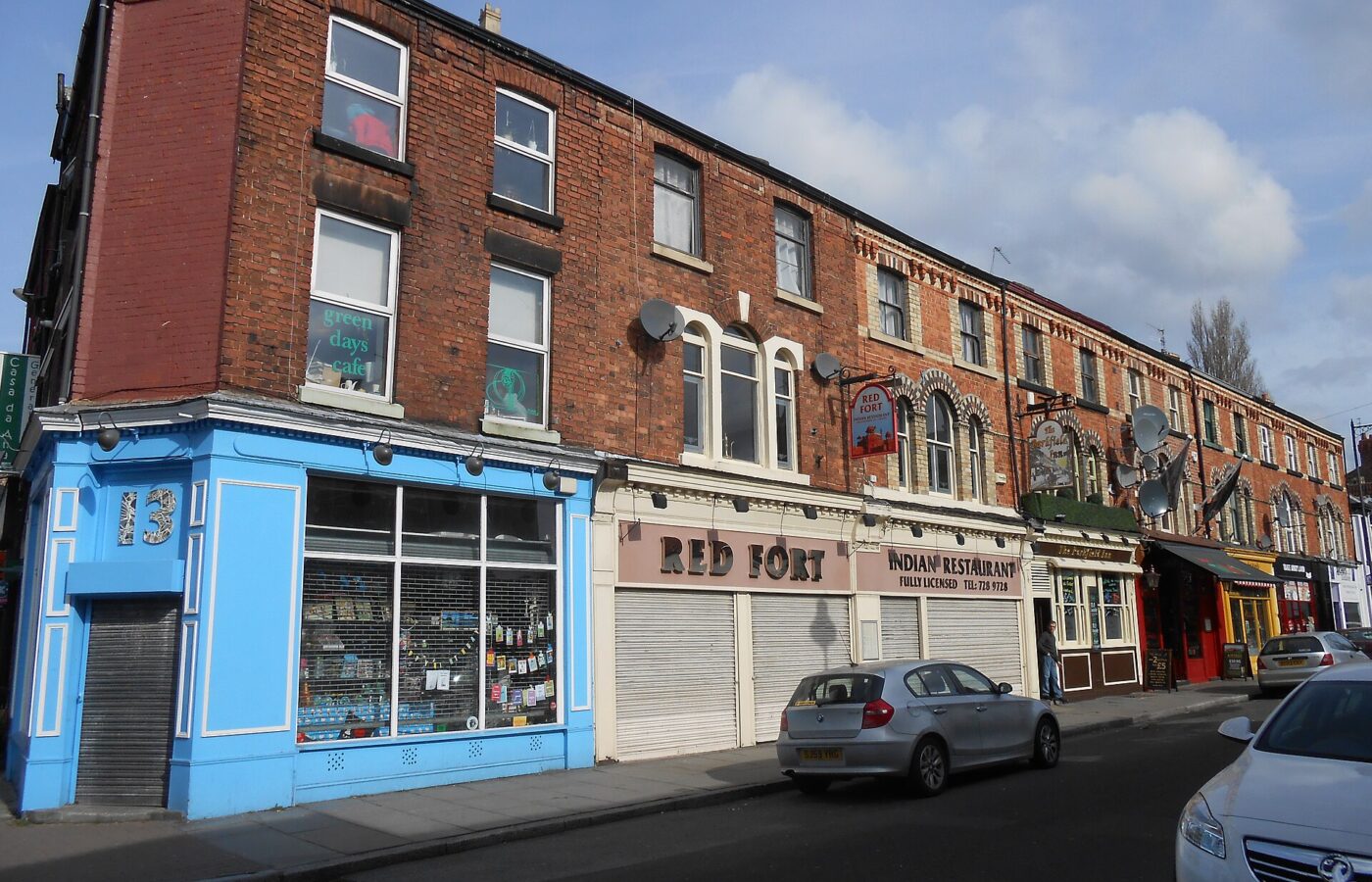 Lark Lane & Aigburth: Liverpool's Bohemian South End 4 A row of Victorian red-brick terraces on Lark Lane in Liverpool with a blue corner shopfront, restaurants and pub signs