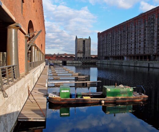 Stanley Dock in Liverpool with the vast Tobacco Warehouse on the right, the Titanic Hotel warehouse on the left and a work boat moored on still water