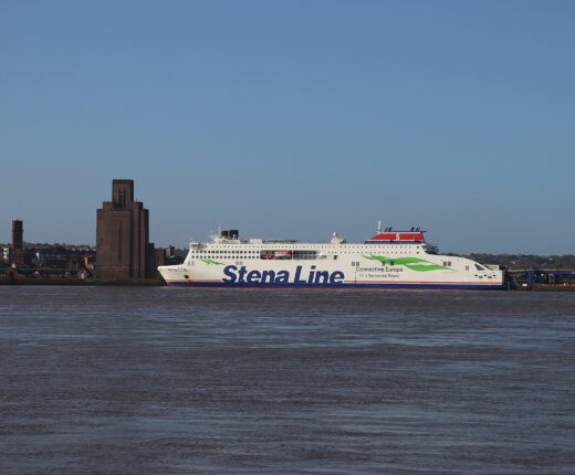 The white Stena Line ferry Stena Edda at its Birkenhead berth, seen across the River Mersey from Liverpool, with the tall brick ventilation tower of the Queensway Tunnel on the left
