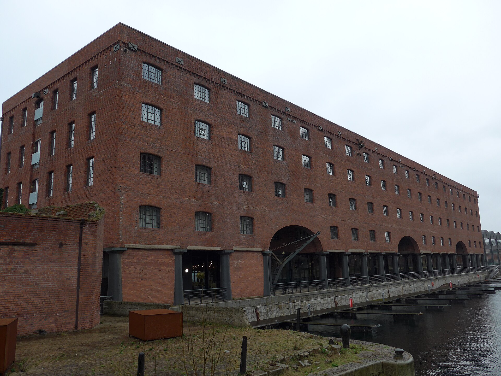 Stanley Dock & the Tobacco Warehouse: Liverpool's Film Backlot 2 The five-storey red brick North Warehouse at Stanley Dock, now the Titanic Hotel, with arched openings, cast-iron columns along the quay, an old dockside crane and pontoons on the water