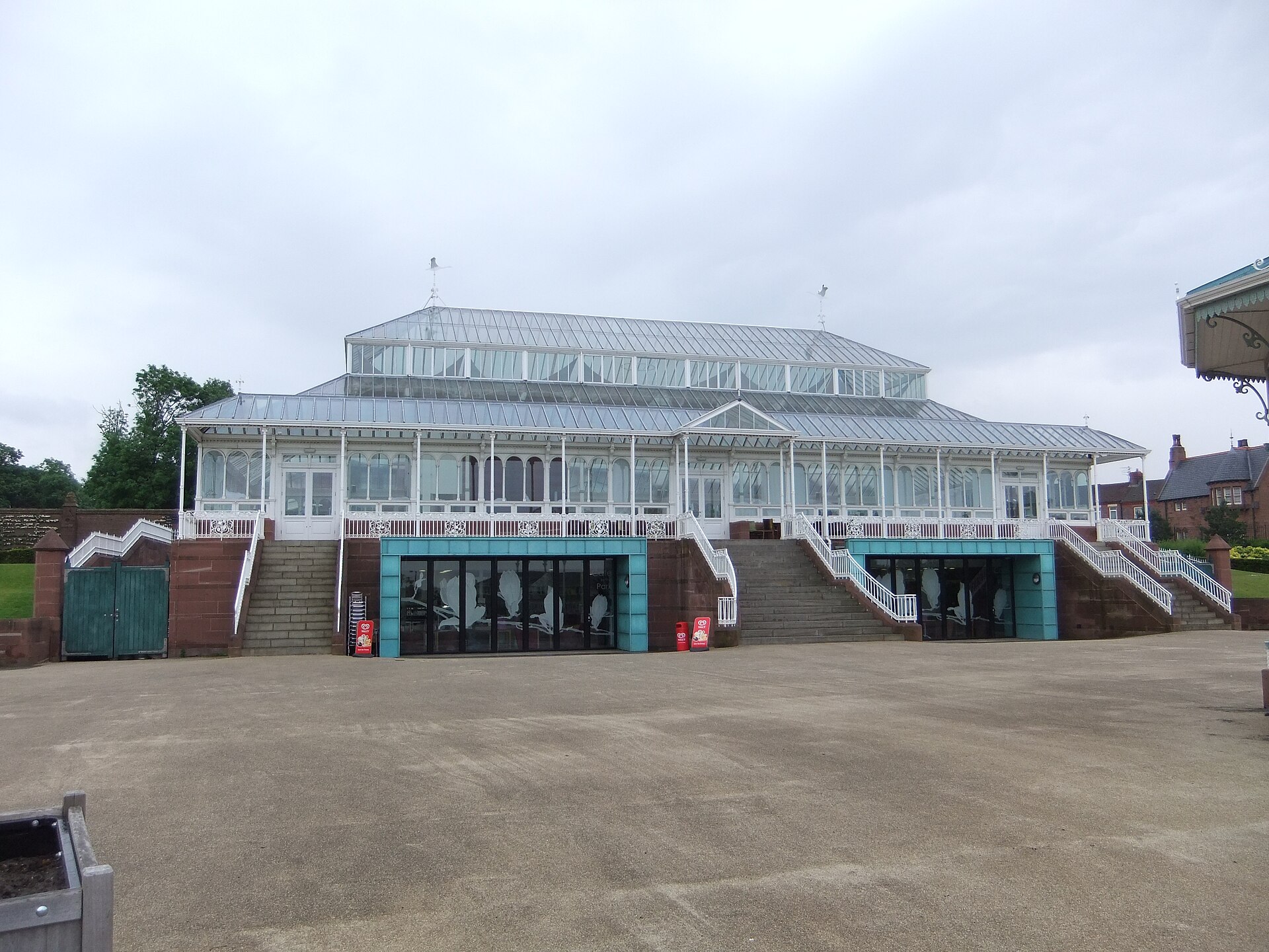 Anfield, Everton & North Liverpool: What's There Beyond the Stadiums 3 The white Victorian glass and iron Isla Gladstone Conservatory in Stanley Park, Liverpool, with a central raised roof, wide steps up to the entrance and a paved forecourt