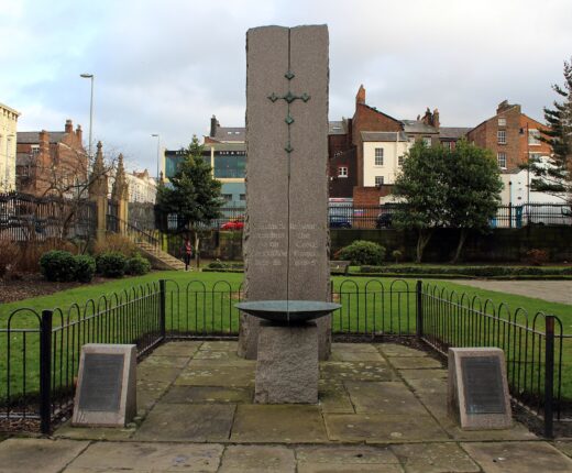 The Irish Connection: Liverpool's Irish Heritage & History 6 Liverpool's Great Famine memorial at St Luke's, with a stone pillar, inset cross and shallow bowl inside low railings.