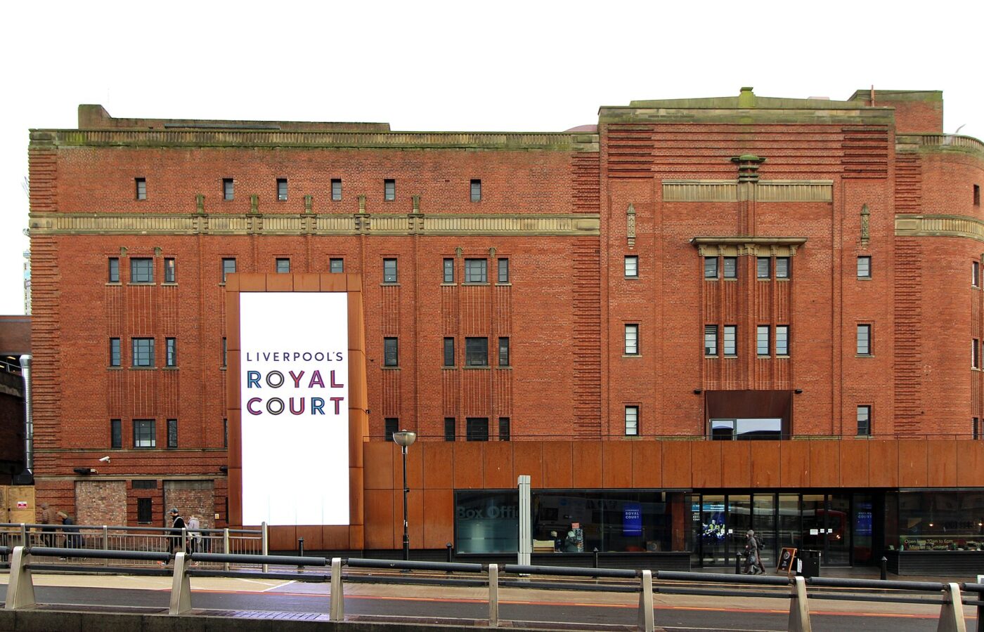 Comedy Clubs in Liverpool: Hot Water, Open Mics & Theatre Stand-Up 5 The red brick Art Deco front of Liverpool's Royal Court theatre with a tall white banner bearing its name and a modern glazed entrance at street level