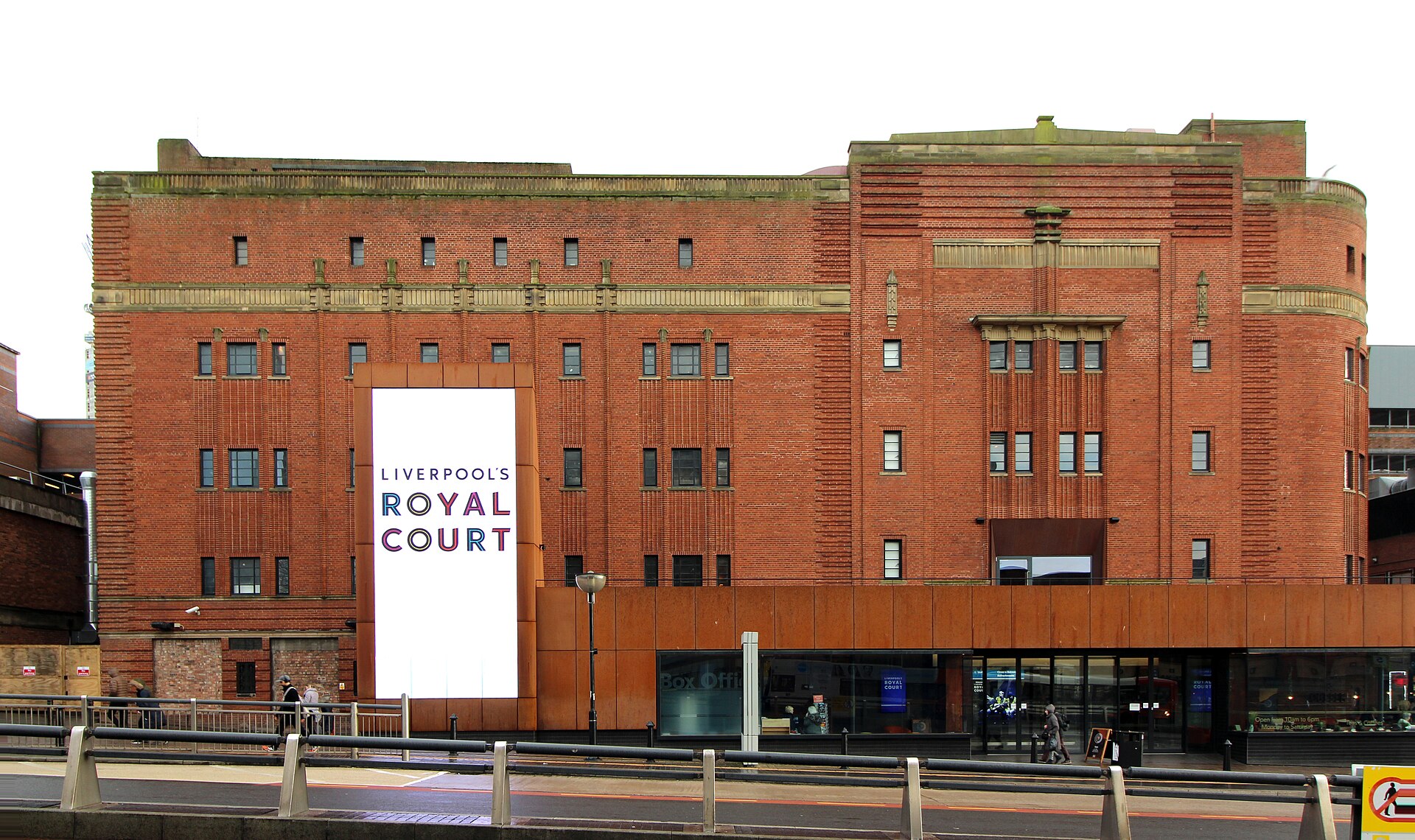 Royal Court Liverpool & Scouse Theatre: Comedies, Christmas & Dinner 2 The red brick Art Deco front of Liverpool's Royal Court theatre with a tall white banner bearing its name and a modern glazed entrance at street level