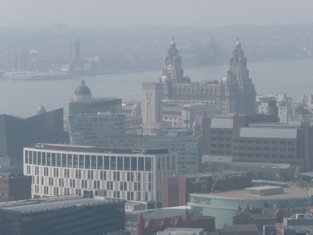 Best Views in Liverpool: Viewpoints, Towers & Skyline Spots 4 A hazy view over Liverpool city centre rooftops towards the Royal Liver Building and the River Mersey, seen from high above