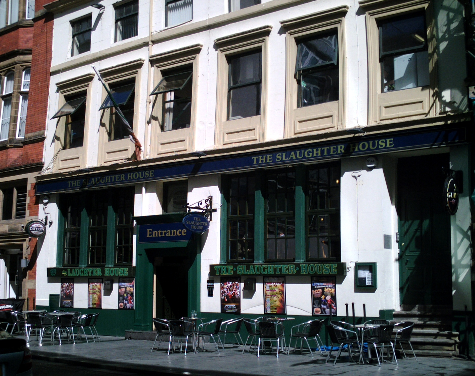 Comedy Clubs in Liverpool: Hot Water, Open Mics & Theatre Stand-Up 1 The cream and green front of the Slaughter House pub on Fenwick Street in Liverpool, with its name in gold letters, an Entrance sign and pavement tables outside